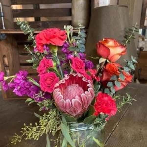 Mixed bouquet with pink and orange roses in a glass vase