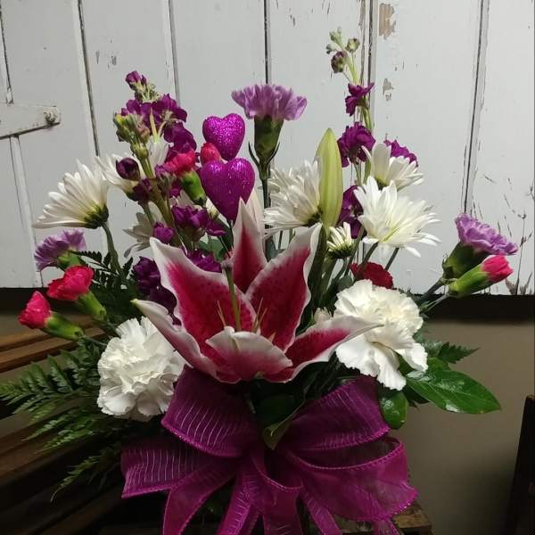 Pink and white mixed flower arrangement with a large ribbon bow