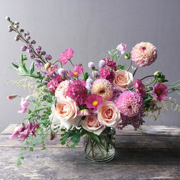 Mixed pink and peach flowers in a clear glass vase