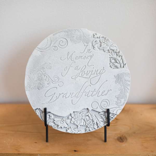 Round memorial plaque on a stand with engraved floral details