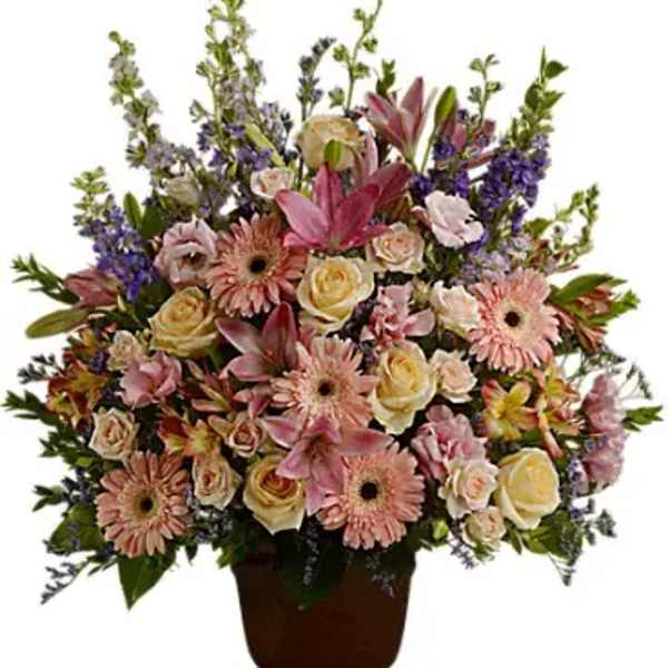 Large mixed flower arrangement in a brown urn vase