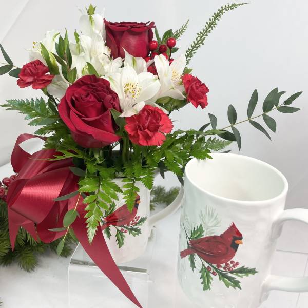 Red roses and white flowers in a mug with a ribbon bow