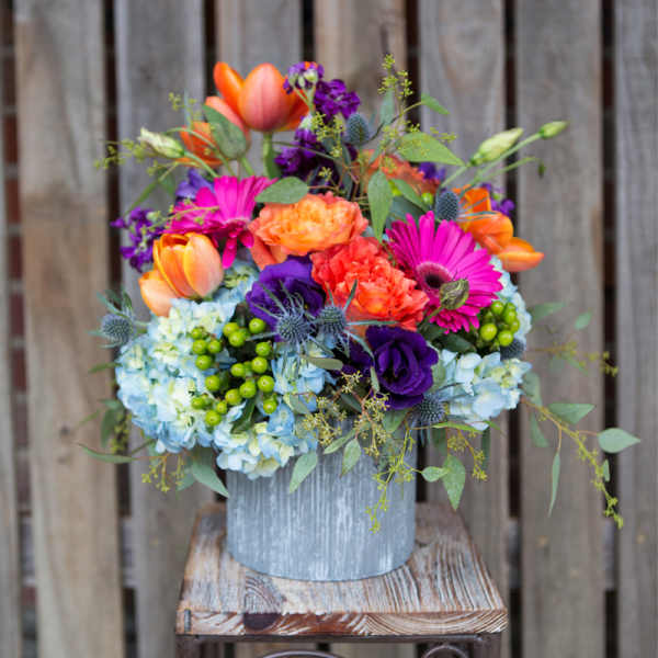 Colorful mixed bouquet in a rustic metal container