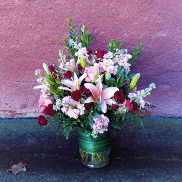 Bouquet of pink lilies and red roses in a glass vase