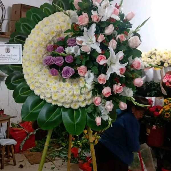 Large standing floral wreath with pink and white roses and lilies