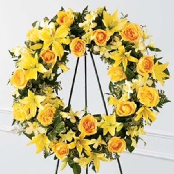 Yellow floral wreath on a black easel stand