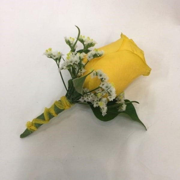 Yellow rose boutonniere with small white filler flowers