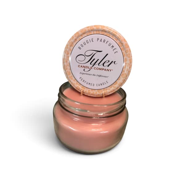 Pink scented candle in a glass jar with a lid