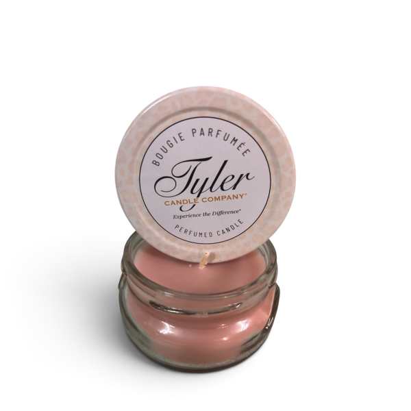 Pink scented candle in a glass jar with a round lid
