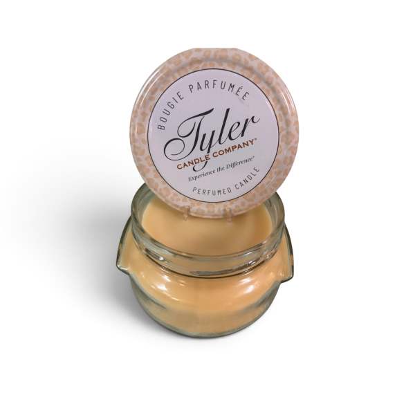A scented candle in a glass jar with a round lid label