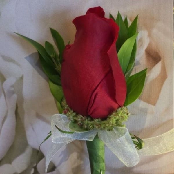 Single red rose boutonniere with white ribbon and greenery