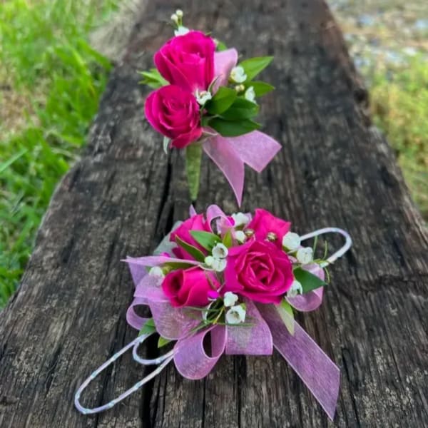 Pink rose corsage and boutonniere with ribbon on a wooden bench