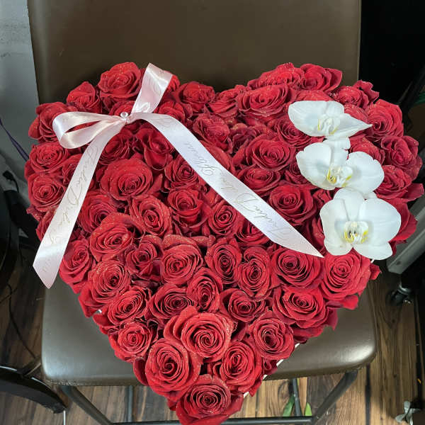 Heart-shaped bouquet of red roses with white orchids and a satin ribbon