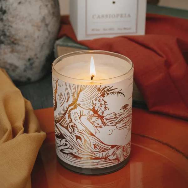 Lit candle in a glass jar with a decorative label