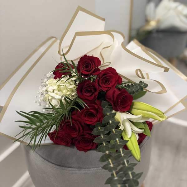 Bouquet of red roses with white lilies in white and gold wrap