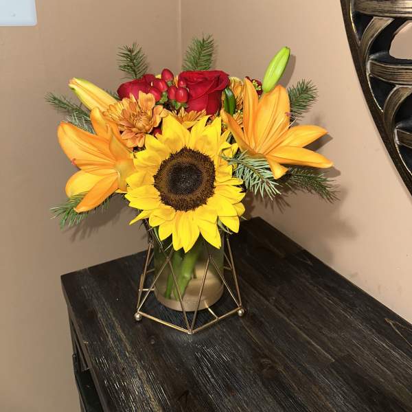 Bouquet with a sunflower, red roses, and orange lilies in a vase