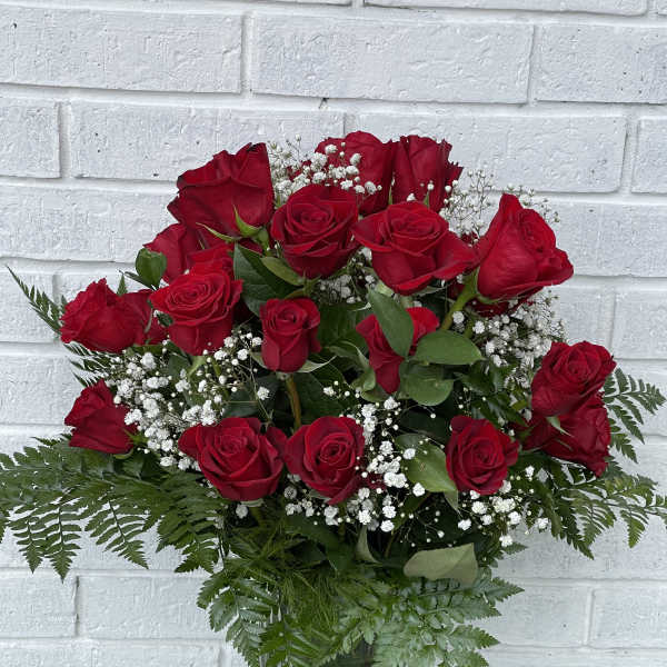 Bouquet of red roses with baby's breath in a glass vase