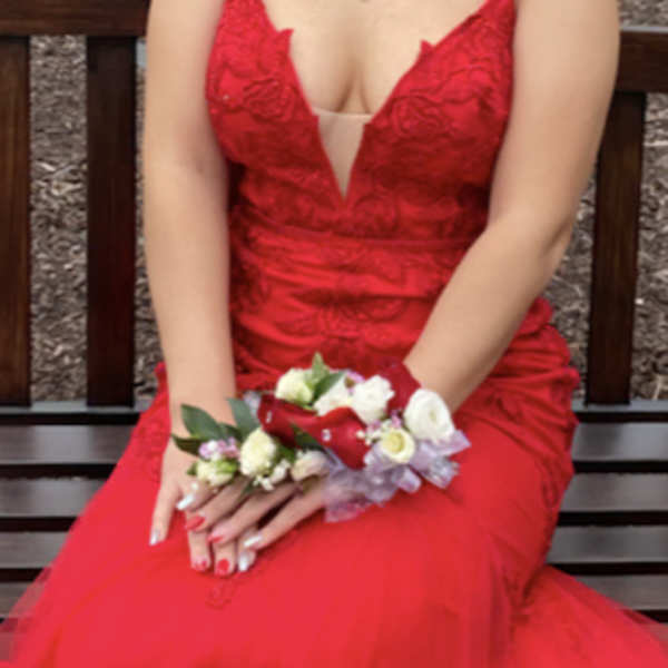 Woman in a red dress holding a floral wrist corsage