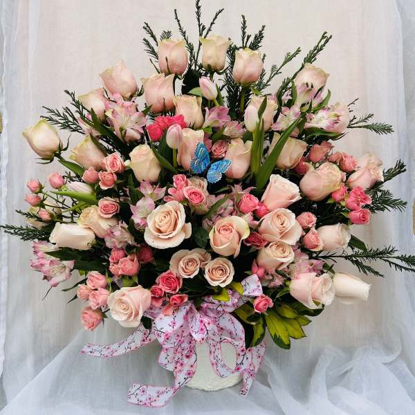 Large bouquet of pale pink roses and pink alstroemeria in a white vase