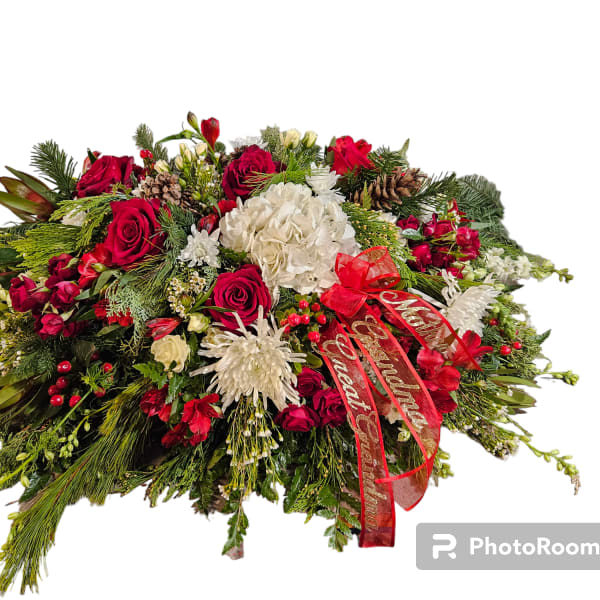 Large holiday floral arrangement with red and white flowers and a red ribbon