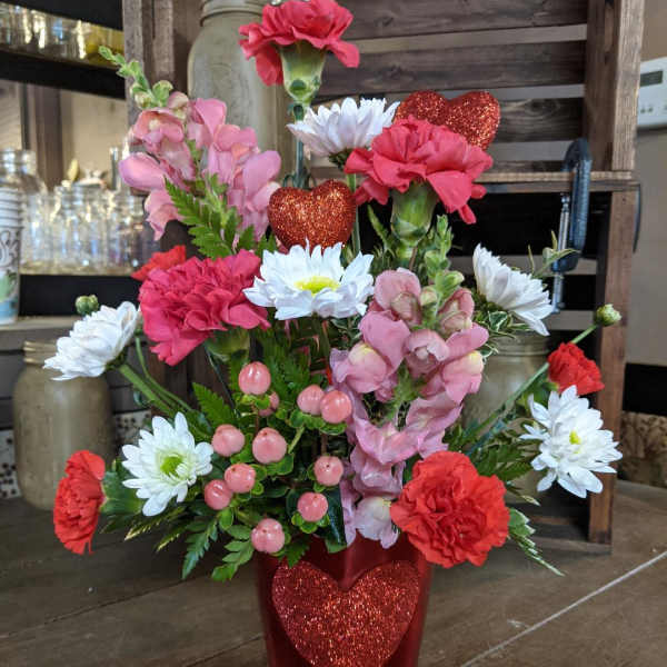 Pink and white flowers in a red glitter heart vase