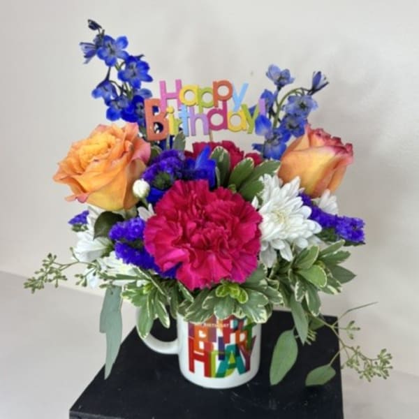 Colorful birthday bouquet in a mug with a Happy Birthday topper