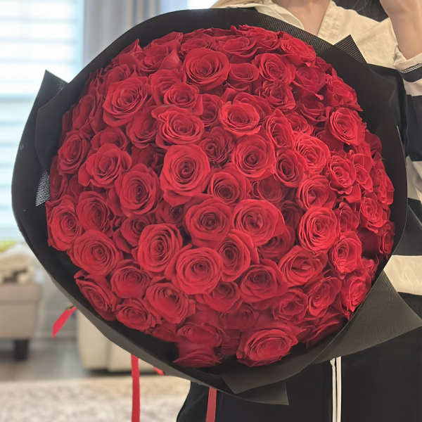 Large bouquet of red roses wrapped in black paper