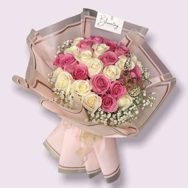 Bouquet of pink and cream roses wrapped in blush paper