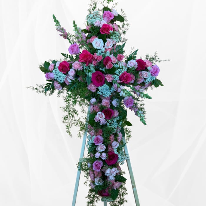 Large pink and white floral cross on a stand