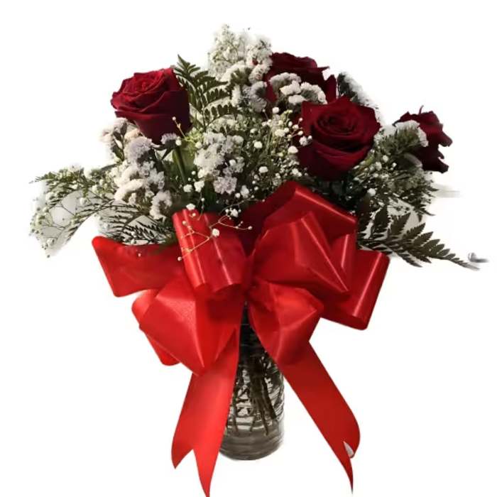 Red roses and white baby's breath in a glass vase with a large red bow