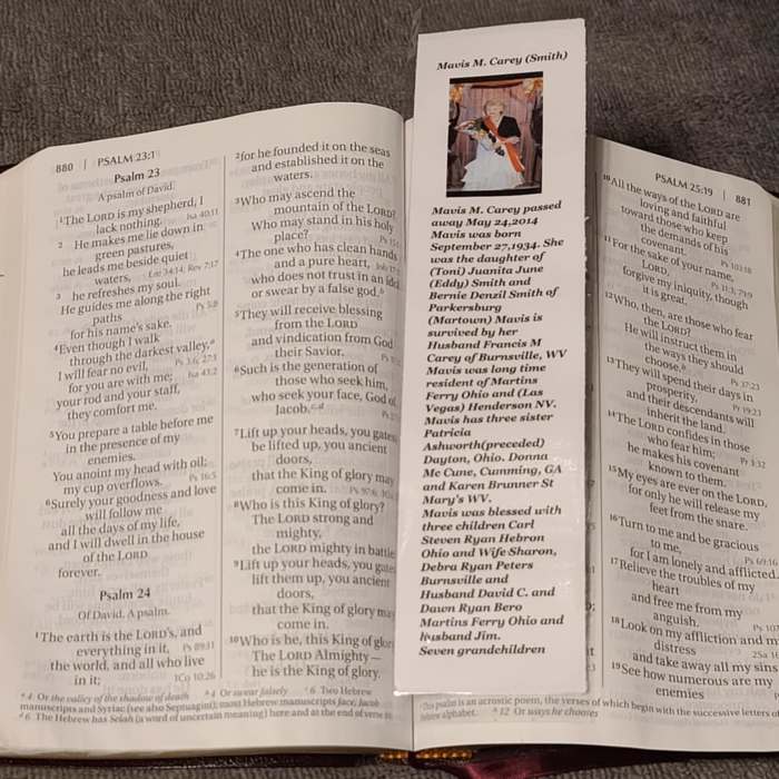 Bible open to Psalms with a memorial bookmark laid across the pages