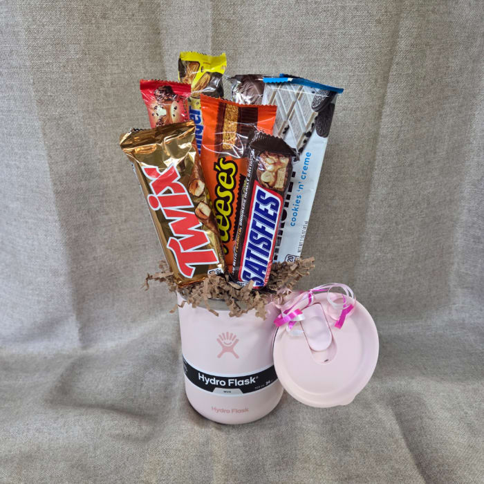 Candy bars arranged in a pink Hydro Flask mug with a matching lid