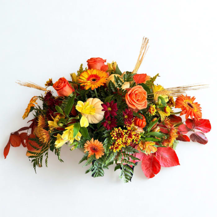 Autumn floral arrangement with orange roses and mixed blooms