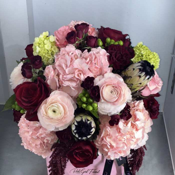 Pink and burgundy bouquet in a pink box with ribbon