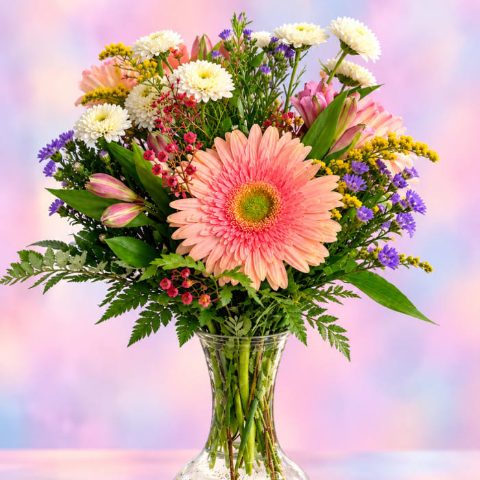 Mixed bouquet with a pink gerbera daisy in a glass vase