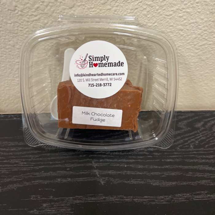 Plastic clamshell container holding a block of milk chocolate fudge