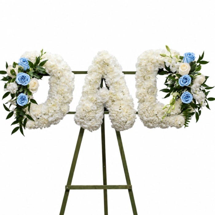 White floral letters on an easel with blue and white rose accents