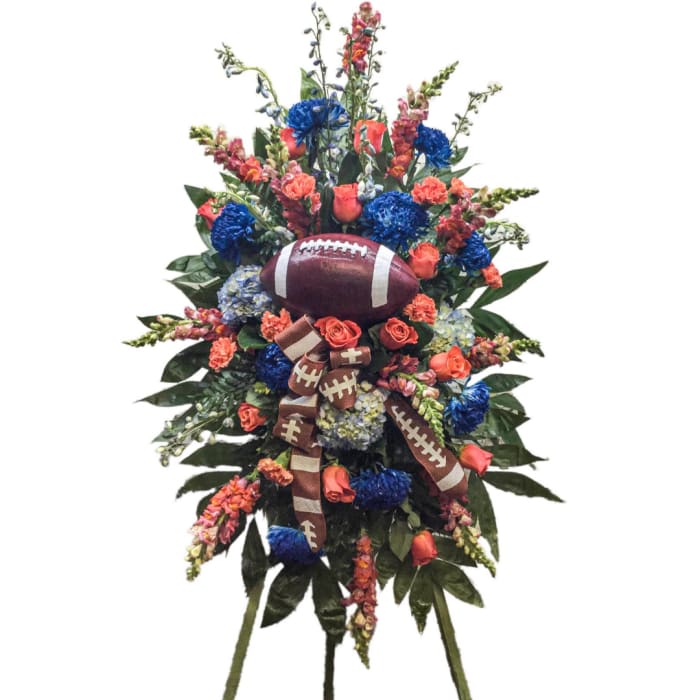Football-themed floral standing spray with blue and orange flowers