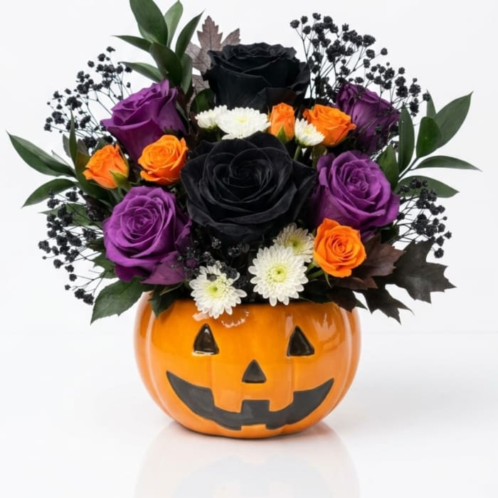 Halloween bouquet in a jack-o'-lantern vase with black, purple, and orange roses