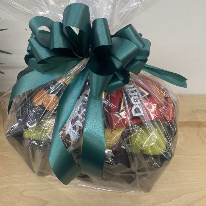Gift basket wrapped in clear cellophane with a teal bow