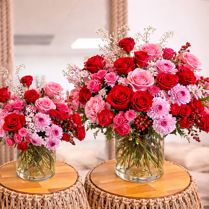 Three red and pink rose bouquets in clear glass vases