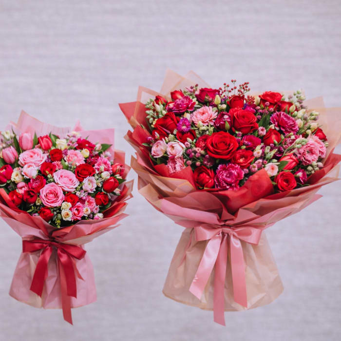 Three bouquets of red and pink roses wrapped in pink paper