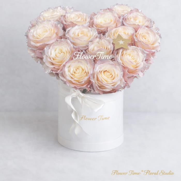 Heart-shaped bouquet of pale pink roses in a white box