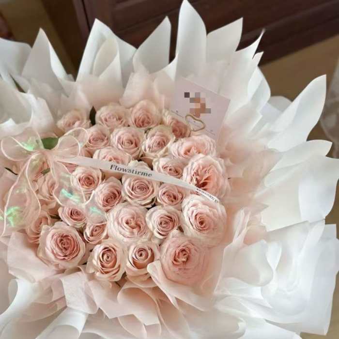 Bouquet of pale pink roses wrapped in white paper