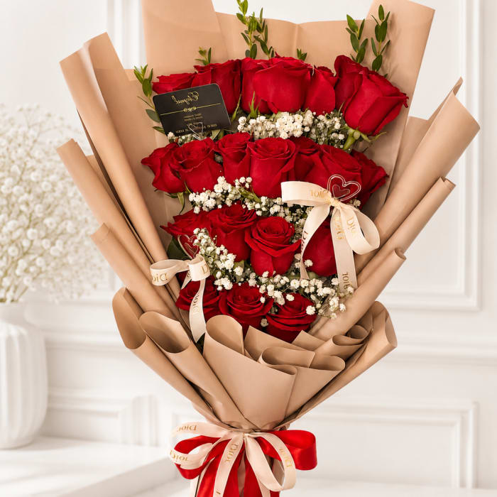 Bouquet of red roses wrapped in tan paper with ribbon