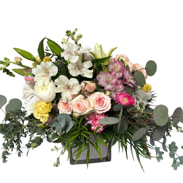 Mixed bouquet of roses, lilies, and alstroemeria in a square vase