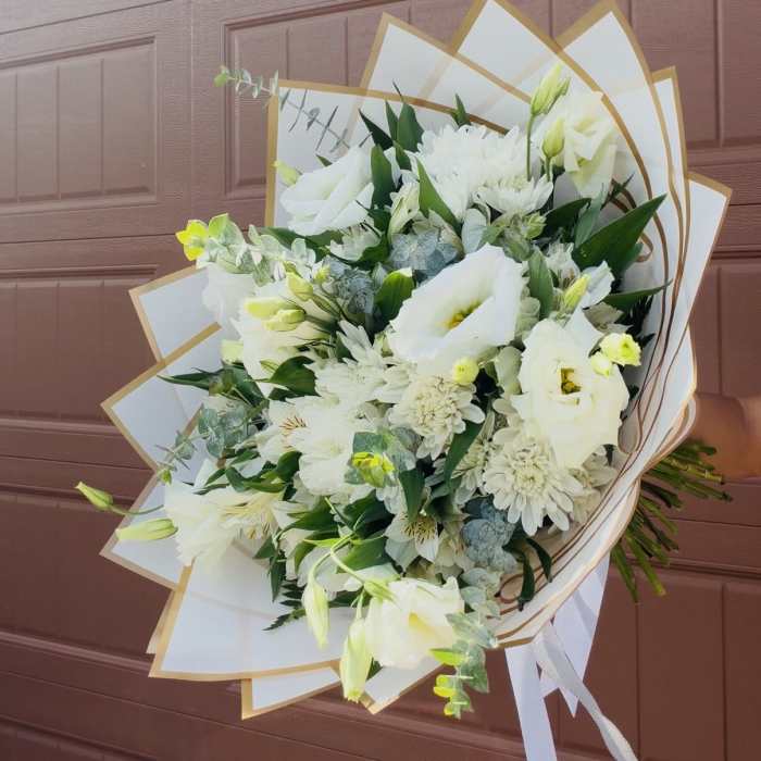 White bouquet with lilies and daisies wrapped in white paper