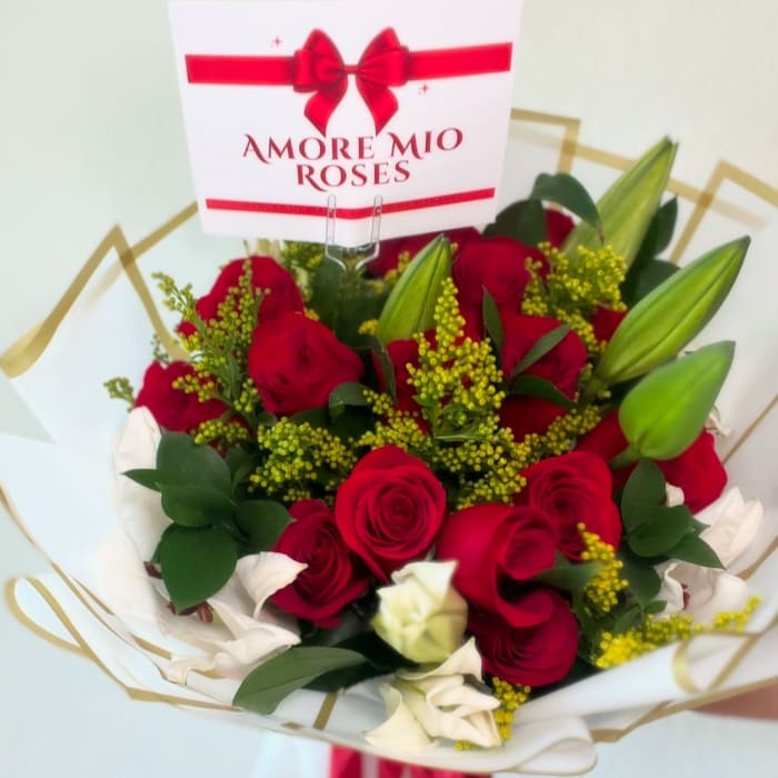 Bouquet of red and white roses with lilies and a gift card