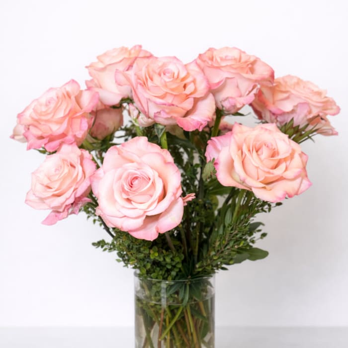 Pink roses arranged in a clear glass vase
