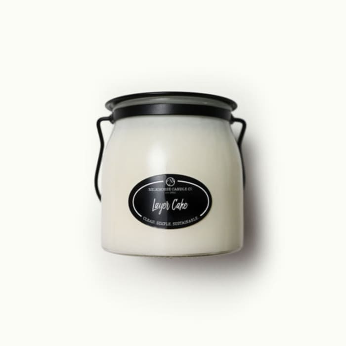 White candle in a black-lidded jar with a handle